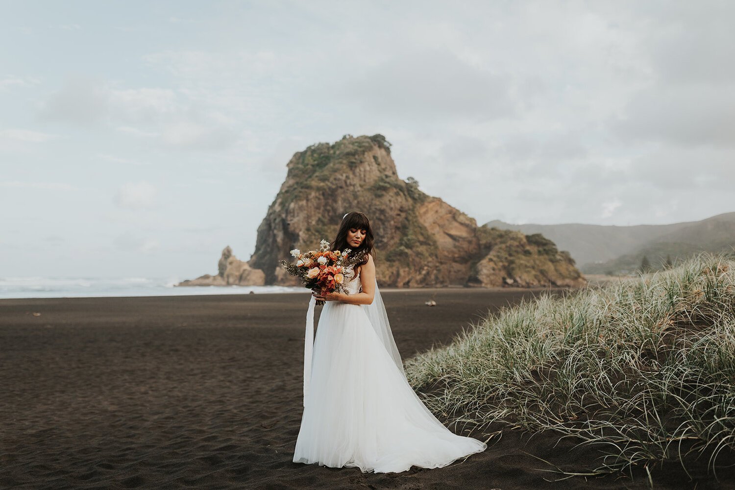 Anni Graham's published after image: the same bride and beach with lighter, warmer tones and a more muted sky.