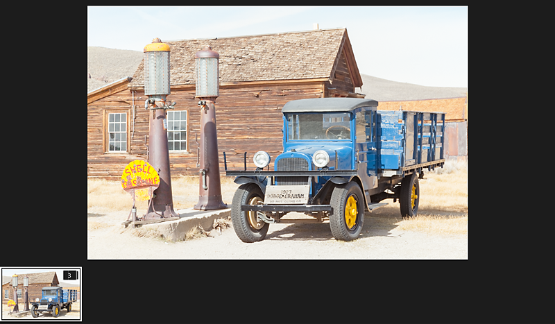 Adobe Lightroom screenshot showing the merged blue truck and wooden building image with a stack thumbnail