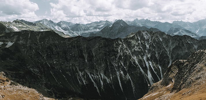 Published Adobe landscape example with nearby rocky slopes, a dark ridge and distant mountains