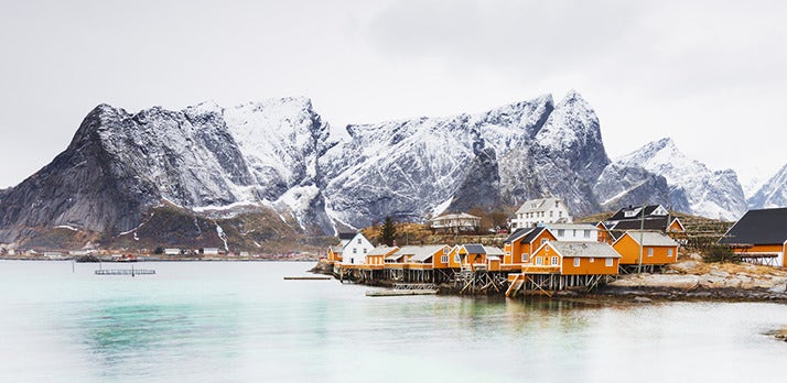 Published Adobe landscape example showing water, yellow waterfront buildings, snowy mountains and pale sky