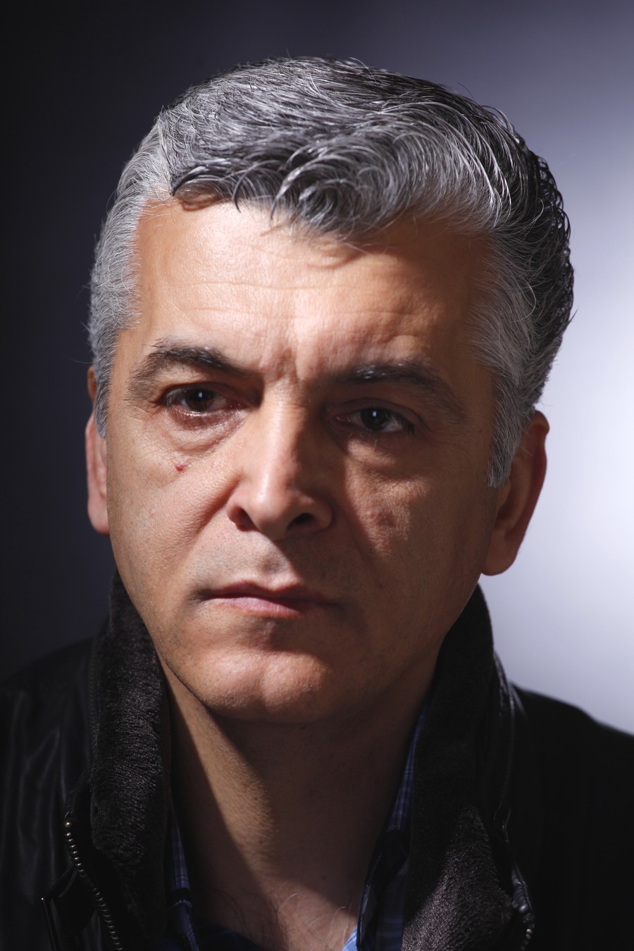 Workshop portrait of a man with a bright cheek on the left of the image and a small lit patch beneath the eye on the darker right cheek
