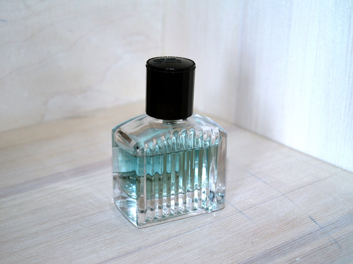Full photograph: clear perfume bottle with black cap; whole bottle visible