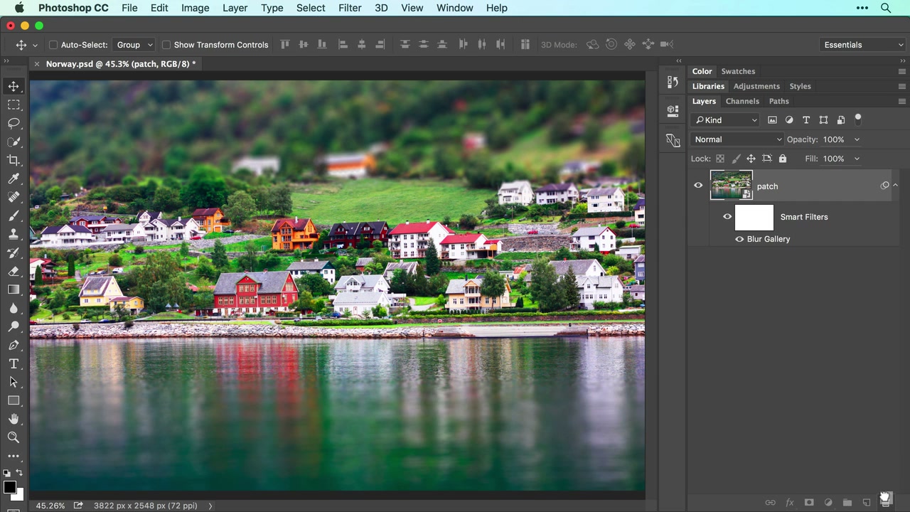 Adobe lesson frame of the same village with sharper central houses and blurred upper hillside and foreground water